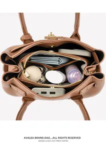 Vue intérieure du sac en cuir marron avec trois compartiments et fermeture dorée