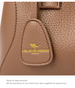 Détails du cuir grainé marron avec texture litchi et étiquette logo kangourou dorée