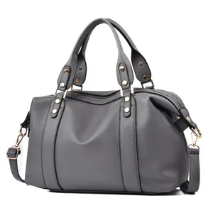 Detail view of grey litchi texture boston bag with golden hardware and round handles