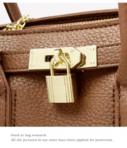 Gros plan du cadenas doré et de la quincaillerie sur un sac à main en cuir marron