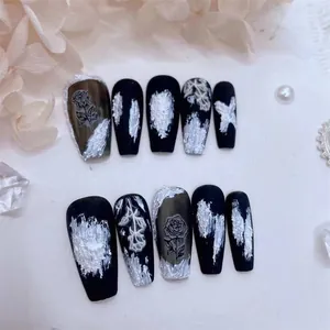 Detail of matte black press-on nails with white oil painting texture and rose design