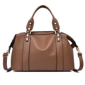 Detail of brown litchi pattern leather boston bag with gold studs and handle