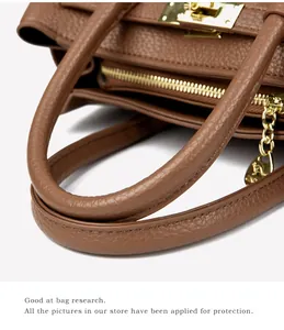 Détails d'un sac à main en cuir marron grainé avec fermoir rotatif doré et finitions chic