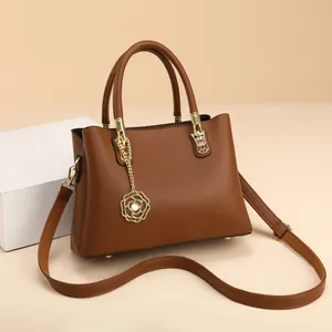 Handtasche aus braunem Kunstleder mit Rosenanhänger und abnehmbarem Schultergurt