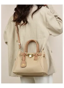Détail du sac à main en cuir kaki clair avec cadenas doré et bandoulière ajustable