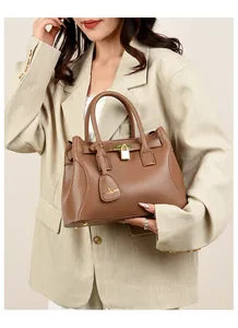 Vue détaillée du sac à main en cuir marron avec cadenas doré et logo de kangourou