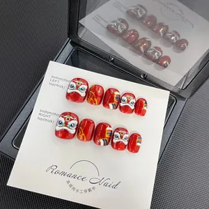 Detail of red Lion Dance embossed press-on nails with 3D relief texture in gift box