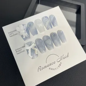Detailansicht handgemachter blau-weißer Nägel mit 3D-Engel und Rosenverzierung