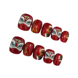 Red festive press-on nails featuring embossed lion dance design and gold glitter finish