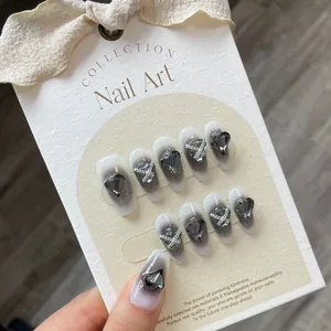 Handmade press-on nails with black and white ombre design, heart rhinestones and silver chains