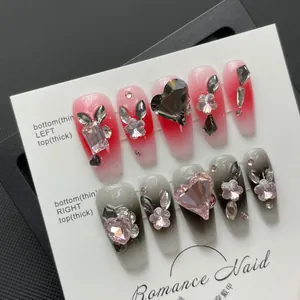 Unghie finte artigianali sfumate con gemme a cuore e strass floreali di forma trapezoidale
