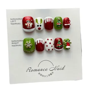 Handmade Christmas press-on nails with 3D reindeer and snowman designs in red and green