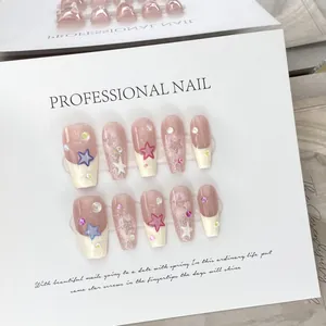 Macro shot of 10-piece coffin press-on nails with star patterns and glitter details