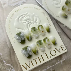 Unghie finte fatte a mano sfumate verde chiaro con farfalle 3D e dettagli in cristallo