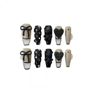 Handmade press-on nail kit with checkerboard patterns, black bows, and heart charms