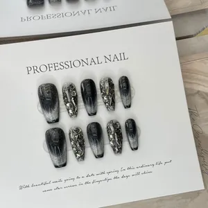Handmade black cat-eye press-on nails with silver rhinestones in a coffin shape