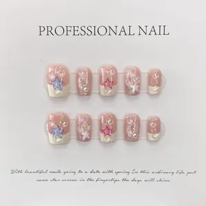 Handmade nude pink and white press-on nails with cute stars and glitter accents