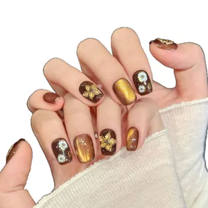 Brown gradient press-on nails with 3D golden flowers and cat-eye finish