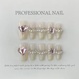 Handmade milky white French press-on nails with pink gems and pearl accents