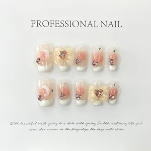 Handgefertigte Kunstnägel mit 3D-Schleifen, rosa Herzsteinen und French-Tip-Design