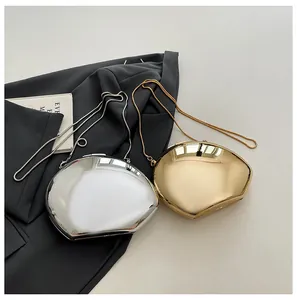 Close-up of metallic egg-shaped evening clutch bags in polished gold and silver finishes