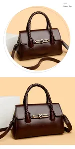 Detailed view of the woven handle and golden kangaroo hardware on dark brown leather bag