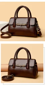 Detail of dark brown leather tote with woven handles and golden kangaroo logo emblem