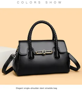 Detail of black leather handbag with braided handle and gold kangaroo logo clasp