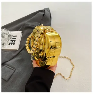 Detail of gold metallic heart-shaped evening bag with pearl handle on grey blazer