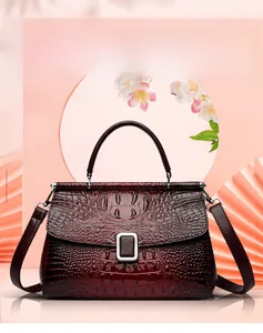 Detail of deep red crocodile pattern bucket bag with silver buckle and top handle