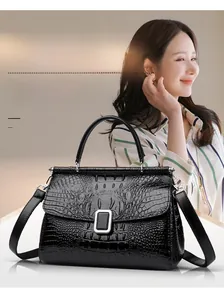 Detail shot of black crocodile pattern faux leather bucket bag with silver metal buckle
