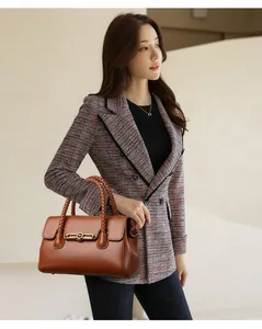 Detail of a brown leather handbag with woven handle paired with a tweed jacket