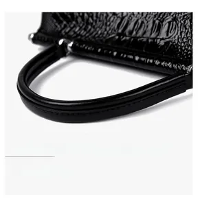 Close-up of black crocodile texture bucket bag with sturdy handle and metal ring connector