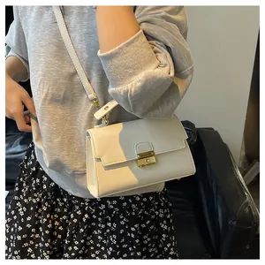 Close-up of white lychee pattern leather bag with gold metal buckle and shoulder strap