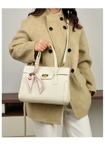 Close-up of cream lychee texture tote with metal twist lock and silk scarf handle detail