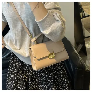 Detail of apricot pebbled leather handbag with gold buckle and top handle styling
