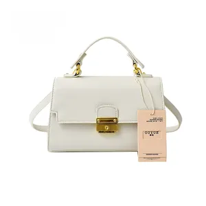 Detail of white lychee pattern handbag with gold clasp and brand product tag