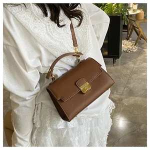 Detail of vintage brown pebble leather crossbody bag with elegant gold metal push-lock