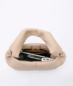 Internal view of the beige dumpling bag showing large capacity and multi-layer storage
