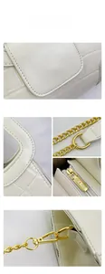Détail du cuir blanc à motif crocodile et de la chaîne en métal doré de luxe