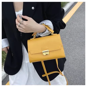 Model wearing a yellow leather handbag with gold buckle against a minimalist outfit