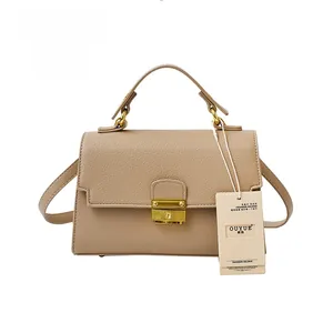 Detailed macro view of light khaki lychee pattern leather with elegant metal handle and lock