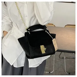 Detail of black vintage wing bag with matte texture and gold chain strap in a studio setting