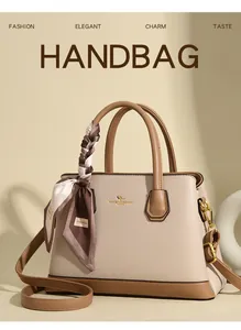 Detail of lychee pattern leather handbag with logo and decorative silk scarf on handle