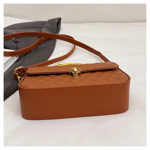 Dettaglio della borsa a tracolla trapuntata marrone con elegante chiusura in metallo oro