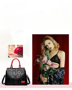 Detail view of black textured tote bag with red handles and Classic brand nameplate