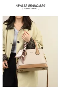 Detail of beige textured leather handbag with contrast base and decorative silk scarf