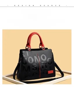 Close-up of black and red contrast handbag with lychee pattern leather and embossing