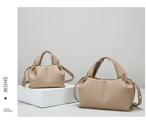 Detail showing two sizes of beige lychee grain leather slouchy dumpling handbags
