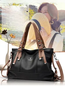 Detail view of large capacity black pebbled leather tote bag with brown handles and straps